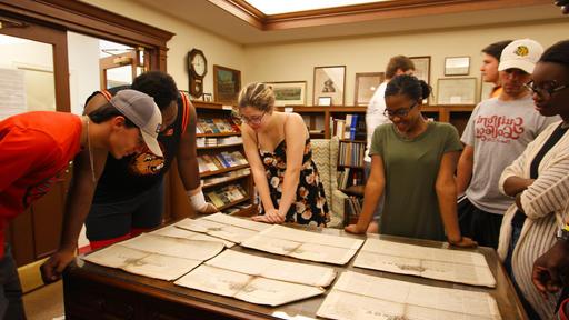 A group of students reviews documents in the Quaker and Special Collections.