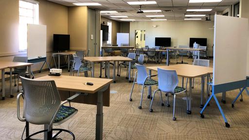 The completed collaboratory is shown, filled with tables, screens, and white boards.